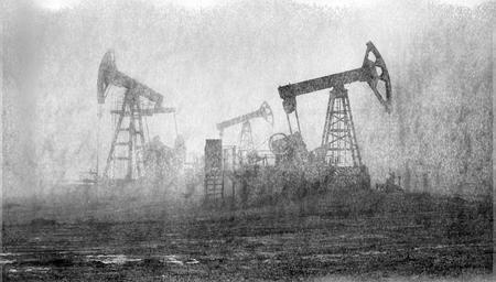 An old film black-and-white image of oil production in America USA. pumps rocking at dawn amid the damaged ecology of alpine meadows work to produce the energy of the modern worldの写真素材
