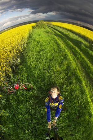 Ukraine, Ivano-Frankivsk, May 21, 2017: bike ride on the background of rapeseed fields, a mountain bike and a symbolic combination of colors of the Ukrainian flag, golden and heavenly.のeditorial素材