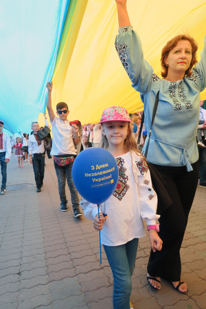 Ukraine, Ivano-Frankivsk - August 24, 2017: Independence Day is a state holiday of a sovereign European country. Townspeople in embroidered shirts sweep the gigantic flag of Ukraineのeditorial素材