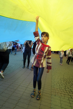 Ukraine, Ivano-Frankivsk - August 24, 2017: Independence Day is a state holiday of a sovereign European country. Townspeople in embroidered shirts sweep the gigantic flag of Ukraineのeditorial素材