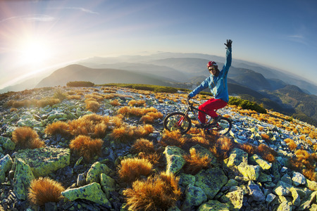 Placer grass similar to a hedgehog with rocks and lichens on a steep slope, a lone rider racer rises to the famous legendary peak of Mount Syvul in the Ukrainian Gorgans in Ukraineの写真素材