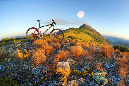 Placer grass similar to a hedgehog with rocks and lichens on a steep slope, a lone rider racer rises to the famous legendary peak of Mount Syvul in the Ukrainian Gorgans in Ukraineの写真素材