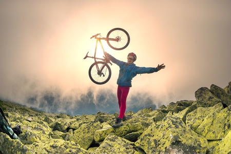 Placer stones with yellow northern lichens on a steep rocky slope, a lone athlete racer rider rises to the famous legendary peak of Mount Syvul in the Ukrainian Gorgans in Ukraineの写真素材