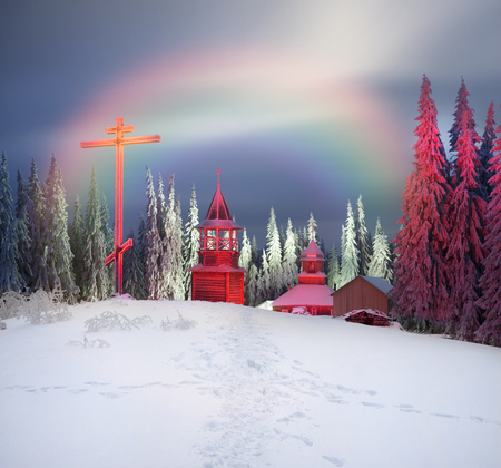 Eastern Europe Western Ukraine lost in the Carpathian mountains Christian monastery and its residential old house lit by streetlights of tourists foggy dawn storm snowy after a frosty nightの写真素材