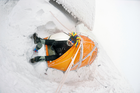 Ukraine, Vorokhta, January 1, 2018: New Year holiday sportsmen of Ukraine ascend to Hoverla mountain. Climber original masked with a beard and hat Rastafarian warm tea for breakfastのeditorial素材