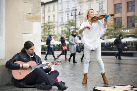 Poland, Krakow, September 14, 2015: Guests of the city, tourists and travelers, townspeople listen...