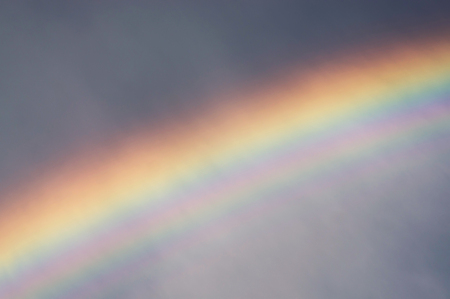 after a rain with a thunderstorm the sun quickly leaves  its bright beams pass through a rain decomposing in millions rain drops - prisms on pure colors of a solar spectrum in a rainbowの写真素材