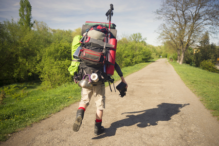 An outdated way of traveling is a huge uncomfortable backpack stuffed with cumbersome heavy equipment. Ancient camera- as a symbol of old-fashioned thingsの写真素材