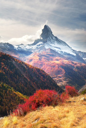 The fall slopes of the resort of Zarmatt are a local landmark and a bright beautiful landscape with the famous Matterhorn peak in autumn in Switzerland.の写真素材