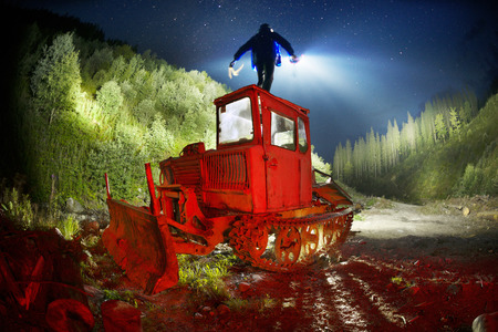 photographer uses unusual methods of photographing with the help of colored lanterns in a mountain hike. An old caterpillar tractor of the Soviet Union is abandoned in the mountainsの写真素材