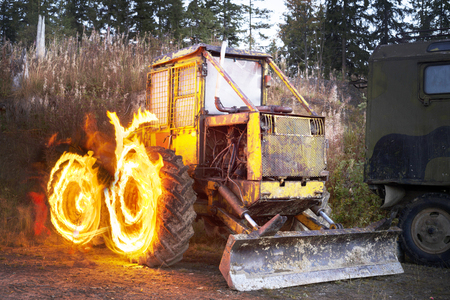 An ancient tractor at the top of the mountain for transportation of coniferous forest is illuminated...