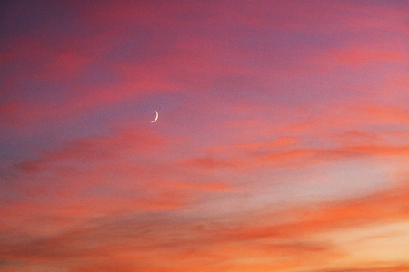Sunset and sunrise with beautiful red clouds and at the same time the east of the Young Moon is a...