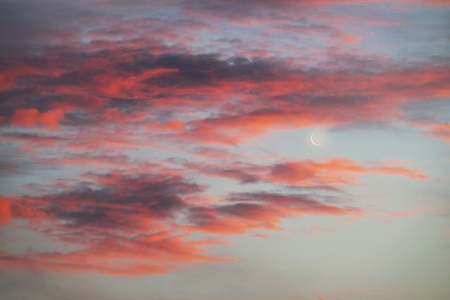 Sunset and sunrise with beautiful red clouds and at the same time the east of the Young Moon is a...