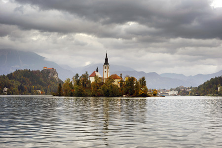 charming small alpine town of Bled with a picturesque island among the lake, a castle on a rocky cliff and the outlines of the Julian Alps in the background - all this creates a stunning landscape.のeditorial素材
