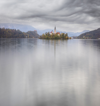 charming small alpine town of Bled with a picturesque island among the lake, a castle on a rocky cliff and the outlines of the Julian Alps in the background - all this creates a stunning landscape.のeditorial素材