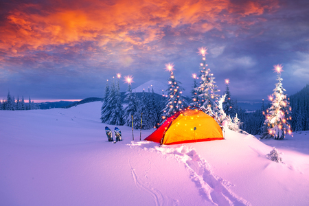 Journey through the winter alpine forests in the wild mountains of Ukraine photographic artist climber tourist equipment, powerful lantern fantasy turns the winter forest into a fairy taleの写真素材