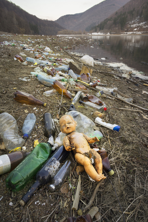 traveler in Ukraine, Kolochava village, photographed a panorama of ecological disaster - in the spring the river carries plastic trash to Europe, abandoned by non-cultural people. Doll symbolizes troubleのeditorial素材