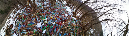 Ukraine, Kolochava, March 21, 2019: A tourist photographed with a mobile phone Xiaomi a panorama of ecological disaster - the river carries plastic waste to Europeのeditorial素材