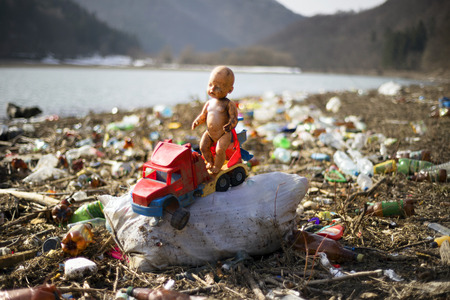 traveler in Ukraine, Kolochava village, photographed a panorama of ecological disaster - in the spring the river carries plastic trash to Europe, abandoned by non-cultural people. Doll symbolizes troubleのeditorial素材