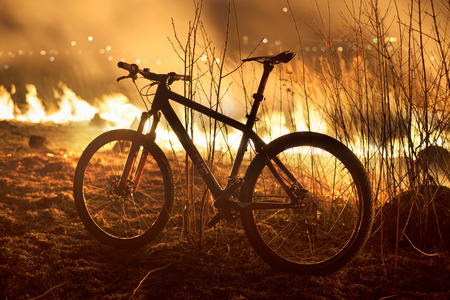 The fire in the field is hot and dangerous, its flame with heat and poisonous smoke, harmful to humans and animals and birds. Bike arriving photographer.のeditorial素材