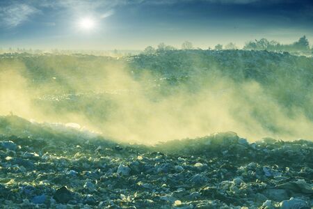 beautiful foggy dawn of the Sun over a huge field of urban garbage, saturated with poisonous fumes...