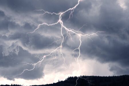 Storm clouds in the Alps after a strong thunderstorm with lightning and thunder over the tops of the ridges, with wind and rainの写真素材
