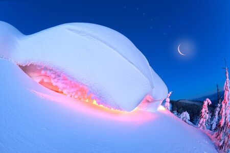 snow cornice at the top is a snow formation formed in the mountains under the influence of wind. Artistic illumination has created a fabulous fiction picture, Ursa Major constellationの写真素材