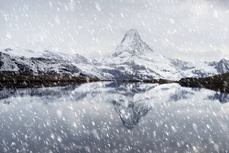 Matterhorn, across from Lake Stellisee  above the city of Zarmatt, is a famous landmark surrounded by larch trees and cliffs, one of the symbols of Switzerland.の写真素材