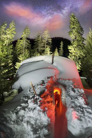 An avalanche mountain shelter in the American mountains. Alpine lifeguards dig up the entrance to a...