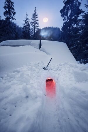 An avalanche mountain shelter in the American mountains. Alpine lifeguards dig up the entrance to a wooden house where tourists can be.の写真素材