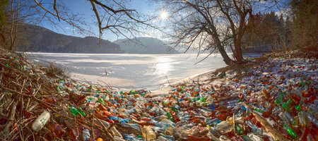 Ukraine, Kolochava, January 20, 2020: Mountain alpine lake in Europe, destroyed by dirty human life. City waste from plastic will spoil the Earth for hundreds of years without decayingのeditorial素材