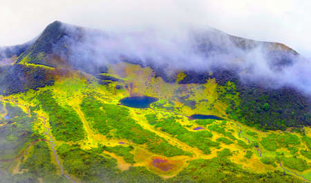 In the mountains of the Carpathians, Ukraine, in a foggy valley of fog, shot by a drone copter, the famous Lake Vorozheska, on Mount Svidovets. Sheep are grazed here in summerの写真素材