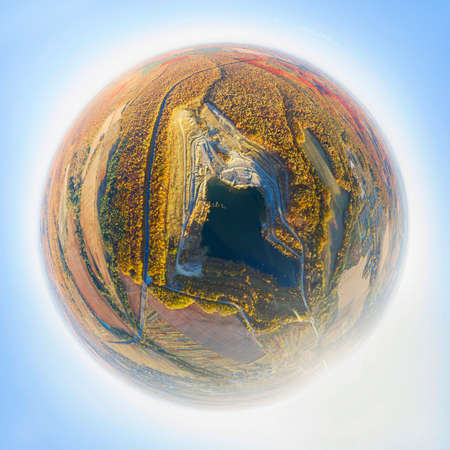 A large clay pit for the production of bricks, with a clean lake in the middle of a beautiful autumn forest in Ukraine. Aerial photo drone copter photo from a bird's eye view.の写真素材