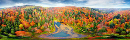 Wild Lake Dead (Polyanitske) near the Dovbush rocks, Bubnishche in autumn among a beautiful autumn forest in the Carpathians, Ukraine. It has a high level of hydrogen sulfide. Aerial photo drone copter photo from a bird's eye view.の写真素材