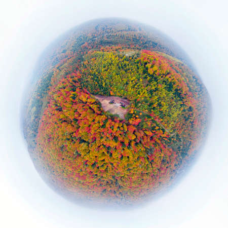 oil gas pump rocking chair in the Carpathians, Ukraine, autumn beech and coniferous forest. Energy...