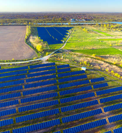 panorama of a field of solar panels providing clean green electricity to European enterprises,...