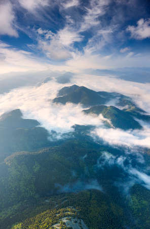 Ukraine, Carpathians, rocky peaks Gorgan - Khomyak and Synyak among wild coniferous and deciduous forests, captured aerially by a drone. After the rain in the valleys, fog and hazeの写真素材