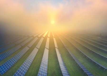 Sunrise in Ukraine, Europe over the field of an ecologically clean source of electrical energy - solar panels. Waves and sea of ââscenic fog give a fabulous magical effectの写真素材