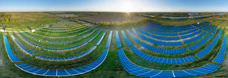 panorama of a field of solar panels providing clean green electricity to European enterprises,...