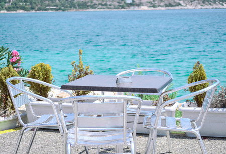 outdoor table and chair near the waterの写真素材