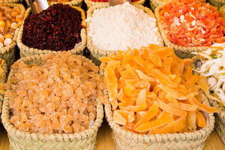 stall of different dried fruit in various wicker basketsの写真素材