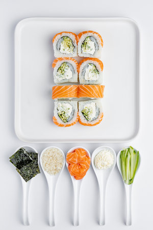 Sushi rolls with salmon, avocado, cucumber and cream cheese on white backgroundの写真素材