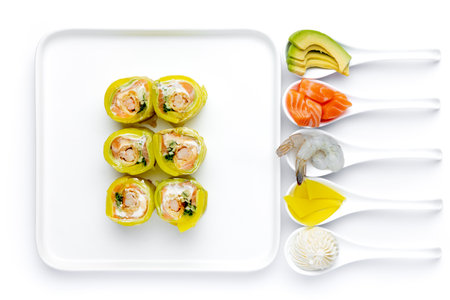 Sushi rolls with salmon, shrimp, avocado and cream cheese on white backgroundの写真素材