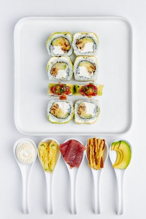 Sushi set on a white background. Sushi rolls with eel, tuna, avocado, cucumber, cream cheese and sauce.の写真素材