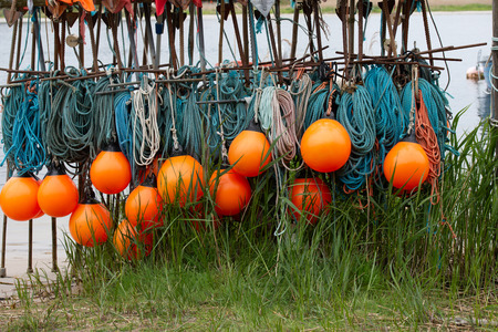 orange buoys with a turquoise fishing netの写真素材
