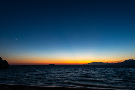 sunset with a dark blue sky turning into bright orange at the south of Creteの写真素材