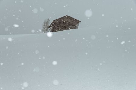 wooden cabin in the austrian alps, covered with snowの写真素材