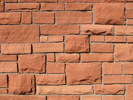 sunlit vivid red cut block sandstone wall の写真素材