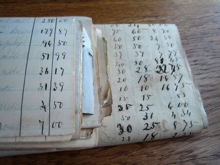 old yellowed accounting papers sitting on a wood deskの写真素材