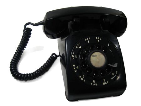 used classic black rotary desk phone with white backgroundの写真素材